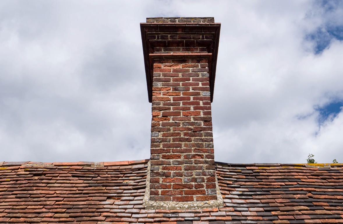 Chimney repair and rebuilding services featuring brick chimney on residential roof in Oceanside, California