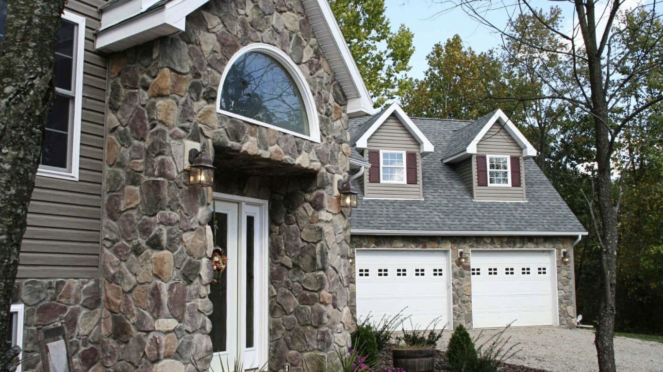Outdoor fireplace and kitchen installation services showing custom stone fireplace with cozy seating area in Oceanside, CA backyard